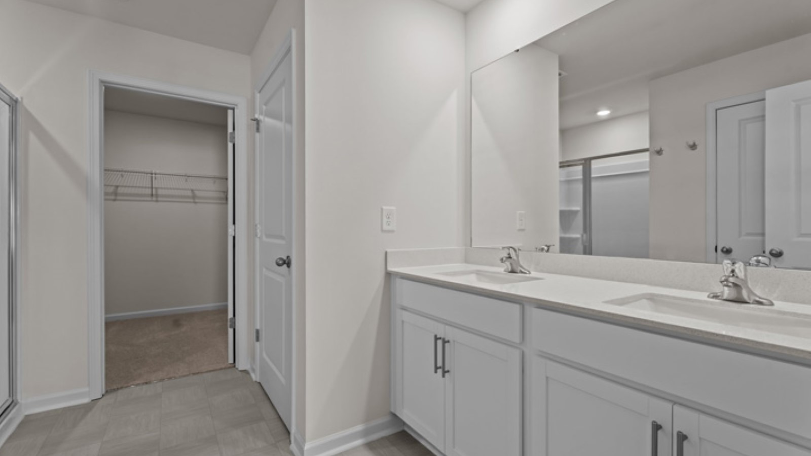 primary bathroom with double sinks and white cabinets