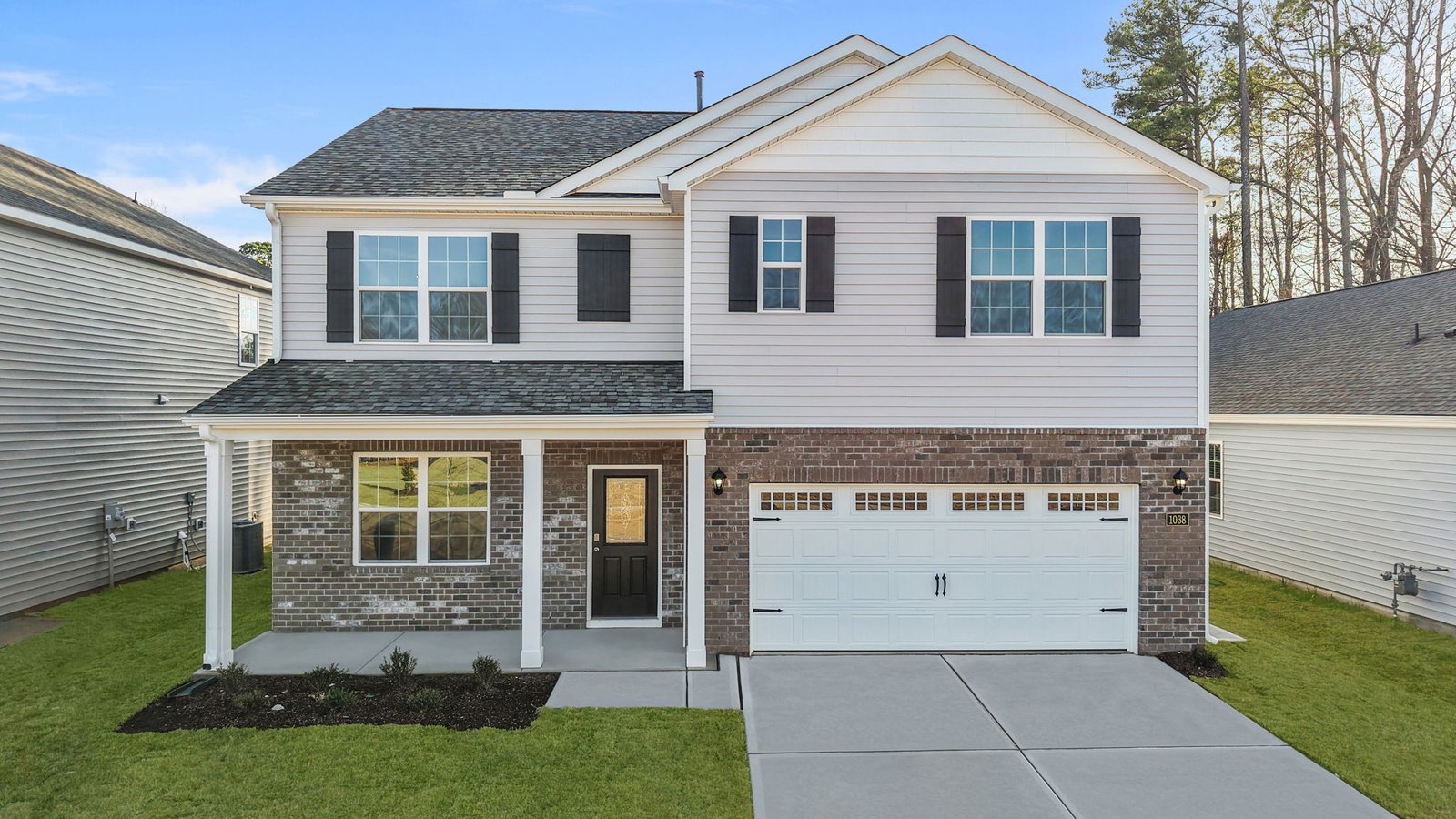 exterior of front of the two story home with brick and vinyl and two car garage