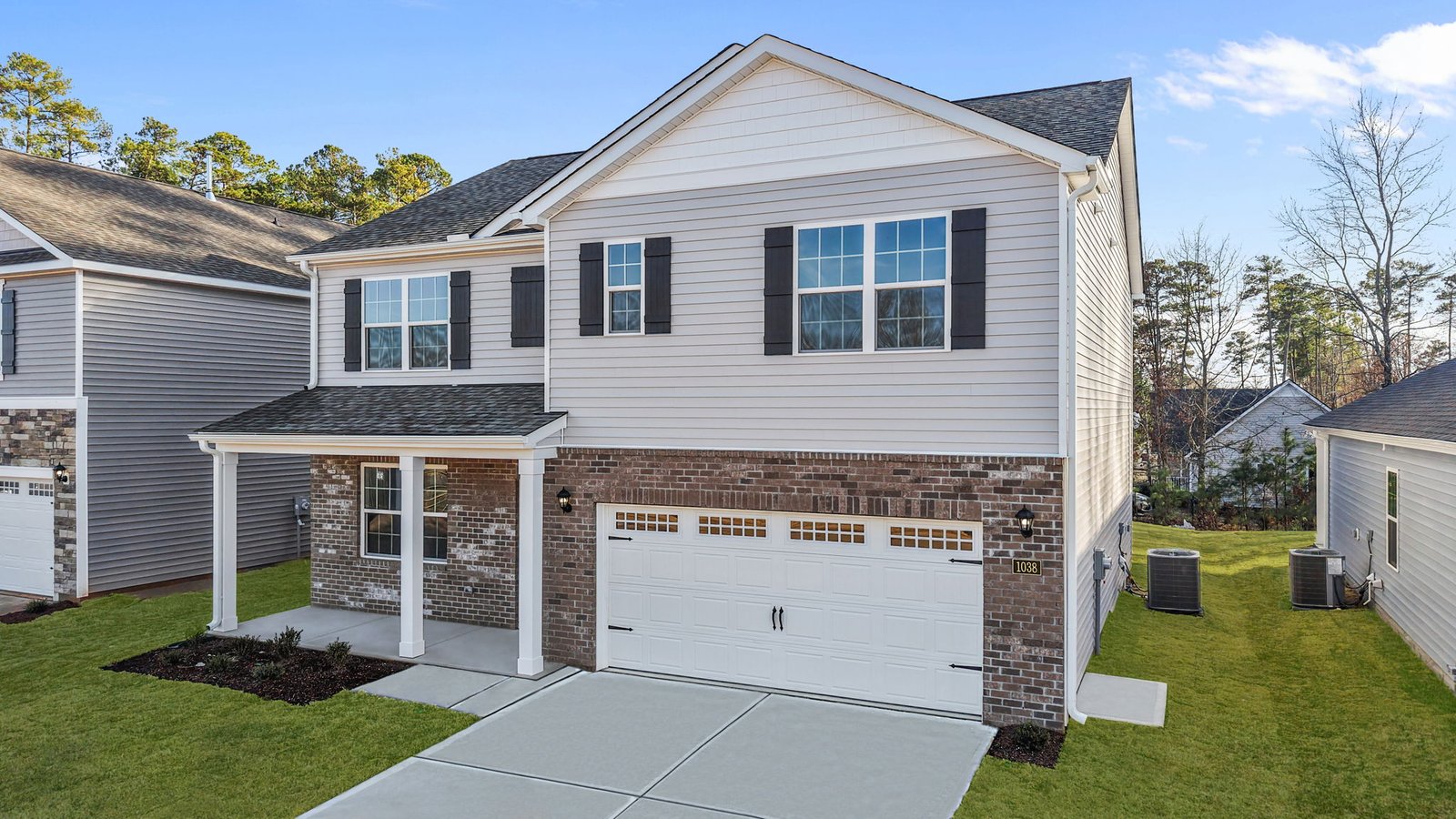 exterior of front of the two story home with brick and vinyl and two car garage