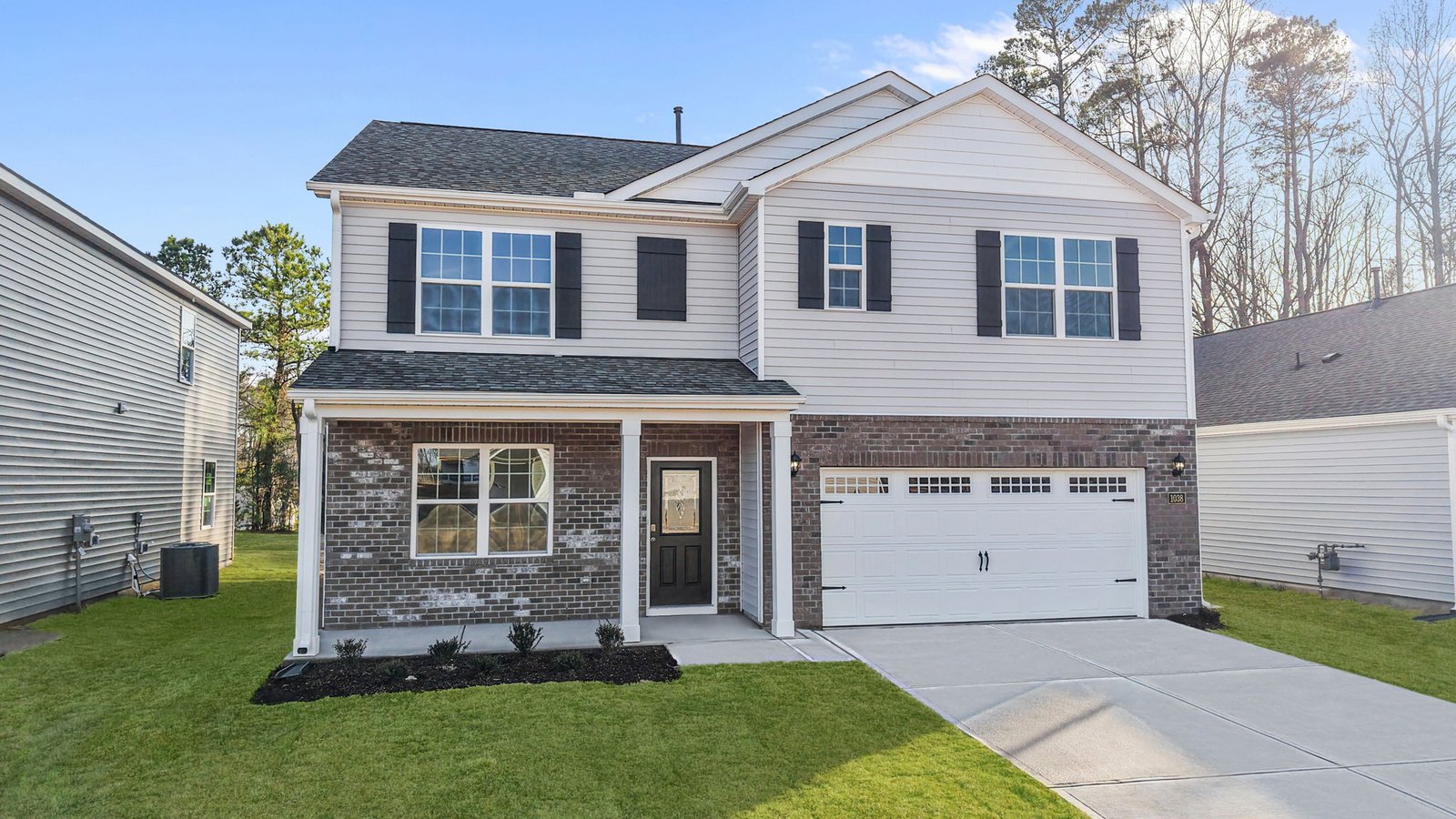exterior of front of the two story home with brick and vinyl and two car garage