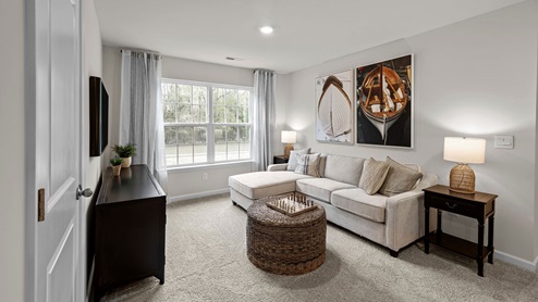 Loft area with carpet flooring and large window