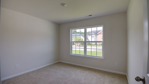 large room with carpet flooring and window for natural lighting