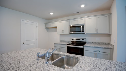 large kitchen with island and granite countertops and stainless steel appliances