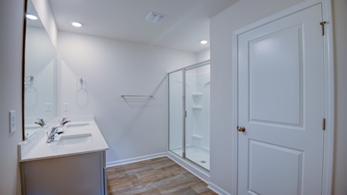 Primary bathroom with double sinks and large closet and walk in shower