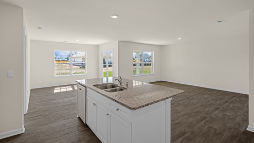 Open kitchen with center island with granite countertops and stainless steel appliances