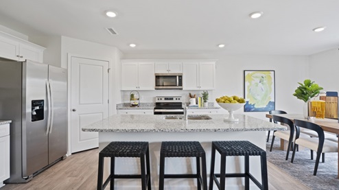 Large Kitchen with stainless steel appliances and large island with granite countertops and white cabinets