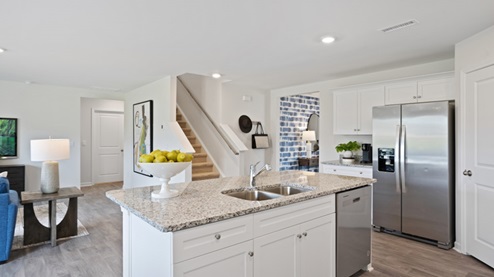 Large Kitchen with stainless steel appliances and large island with granite countertops and white cabinets