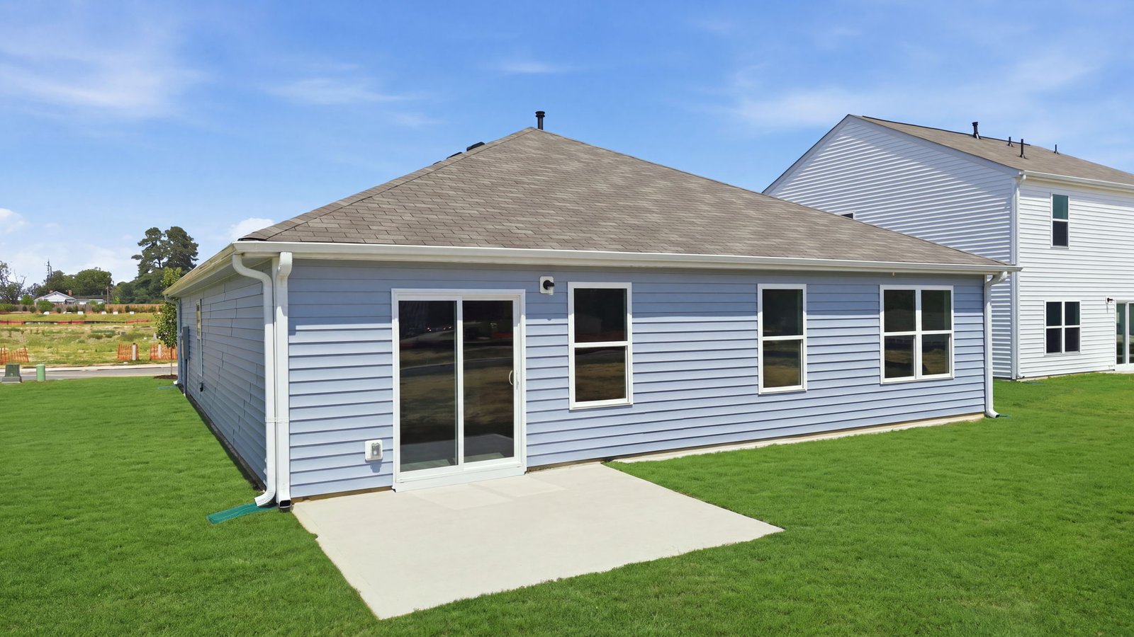 rear view of home and back yard with back patio pad