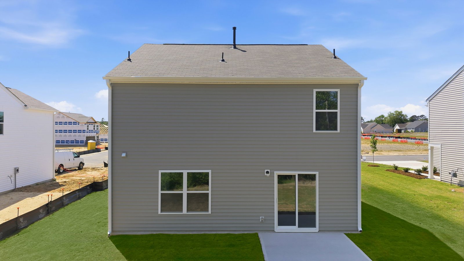 rear view of the two story home with back patio pad