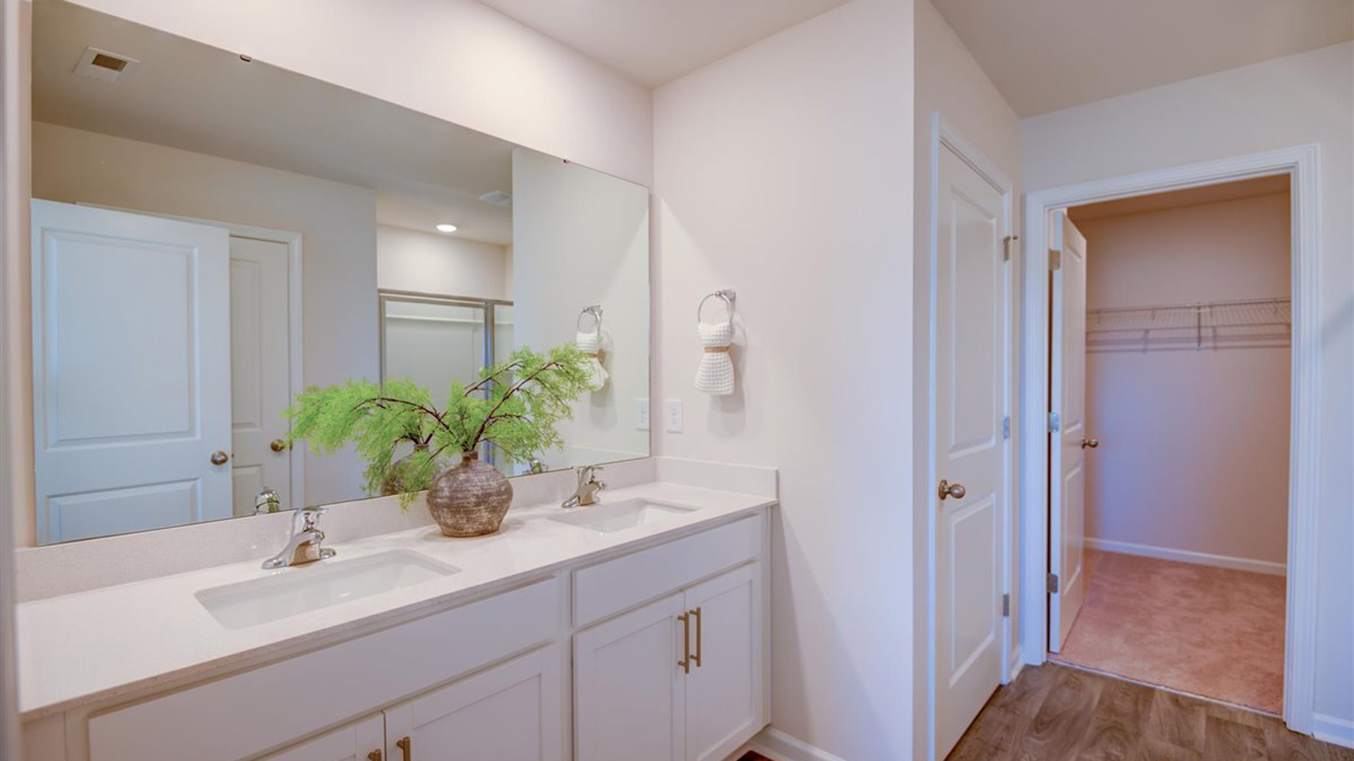 Primary bathroom with double vanity and walk in closet