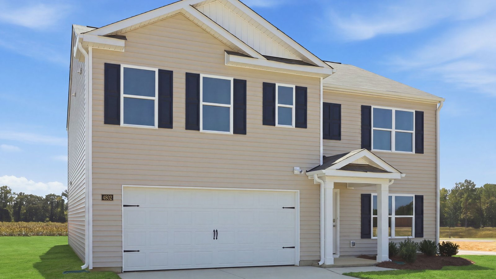 exterior of front of two story vinyl home with two car garage