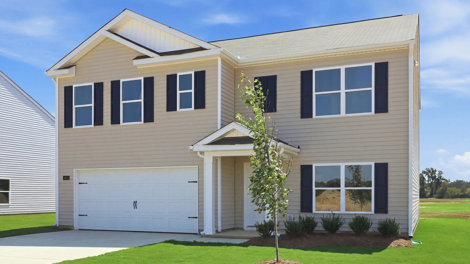 exterior of front of two story vinyl home with two car garage