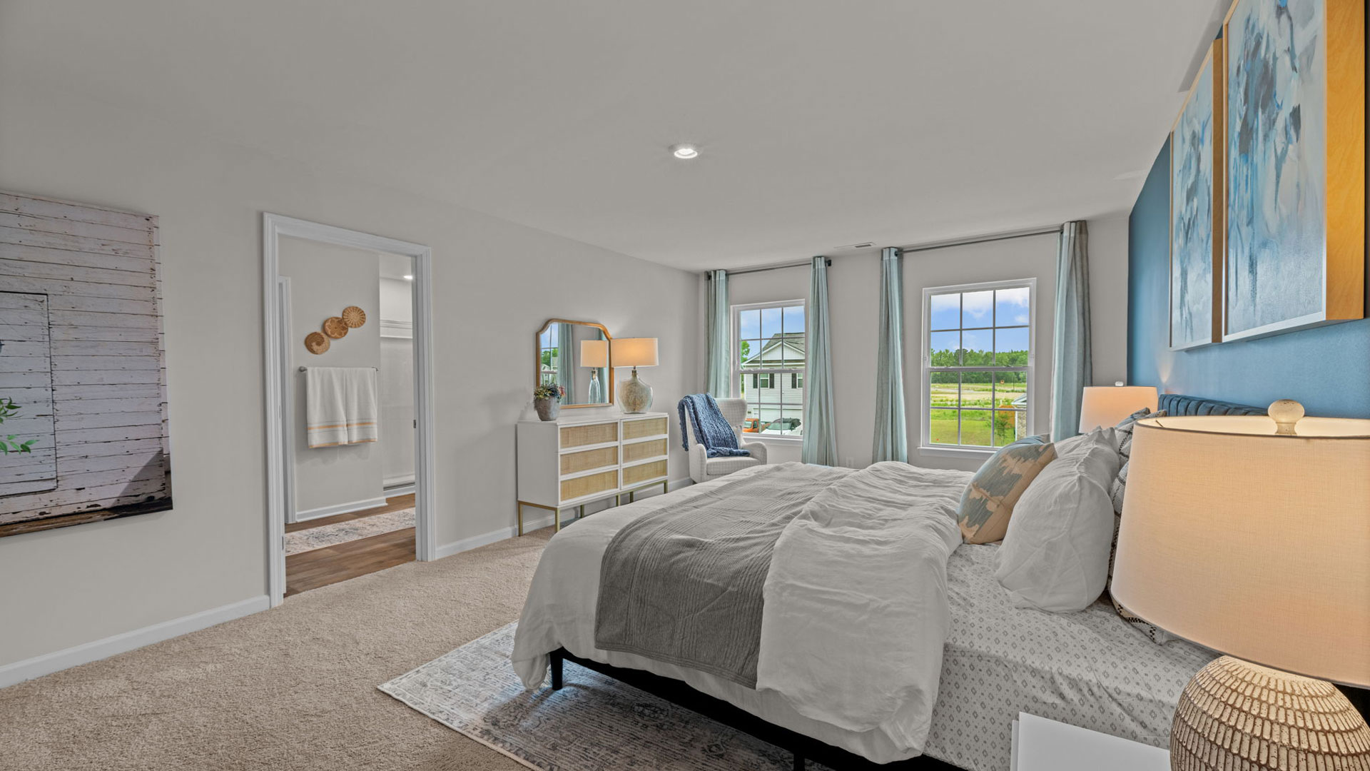 primary bedroom with large windows and ensuite bathroom