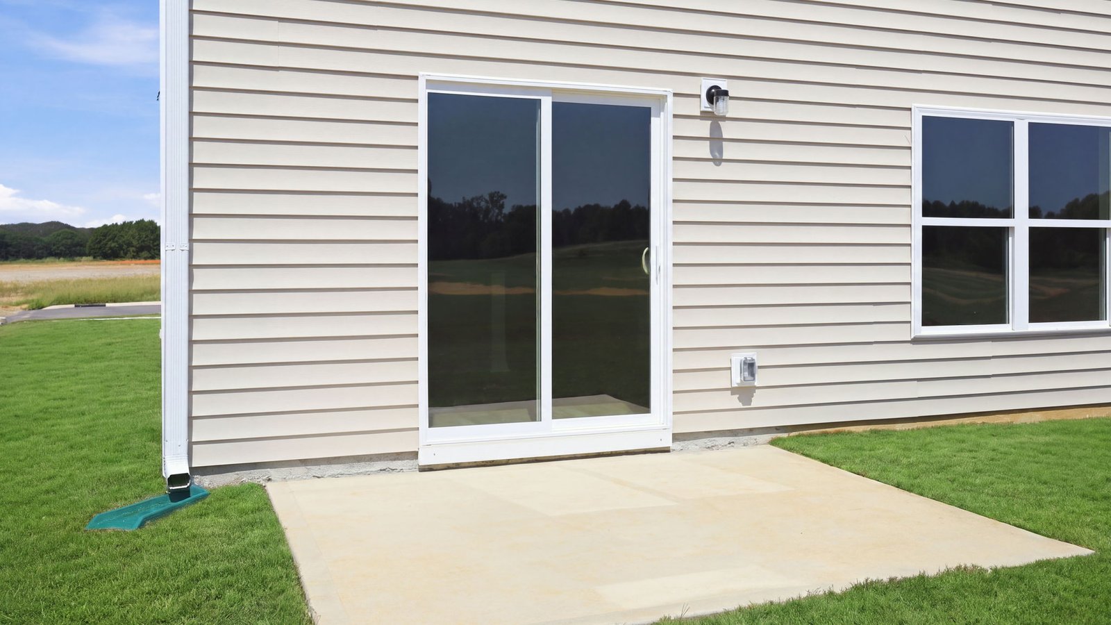 exterior of two story vinyl home with back patio pad
