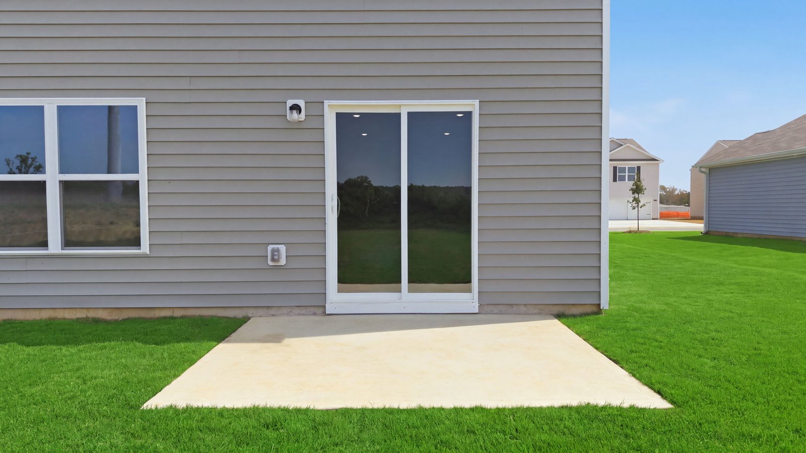 rear view of home with back yard and back patio pad