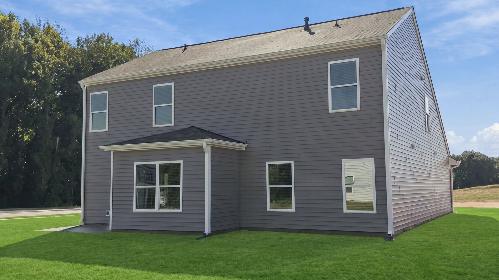 rear view of home and lot and back patio pad