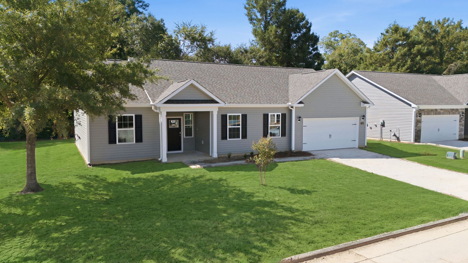 one story vinyl ranch style home with two car garage