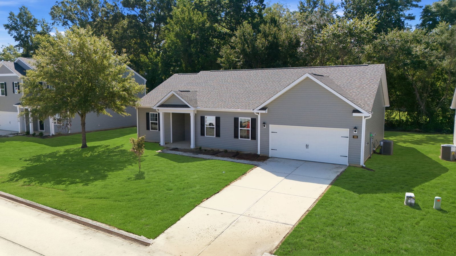 one story vinyl two story home with two car garage and driveway
