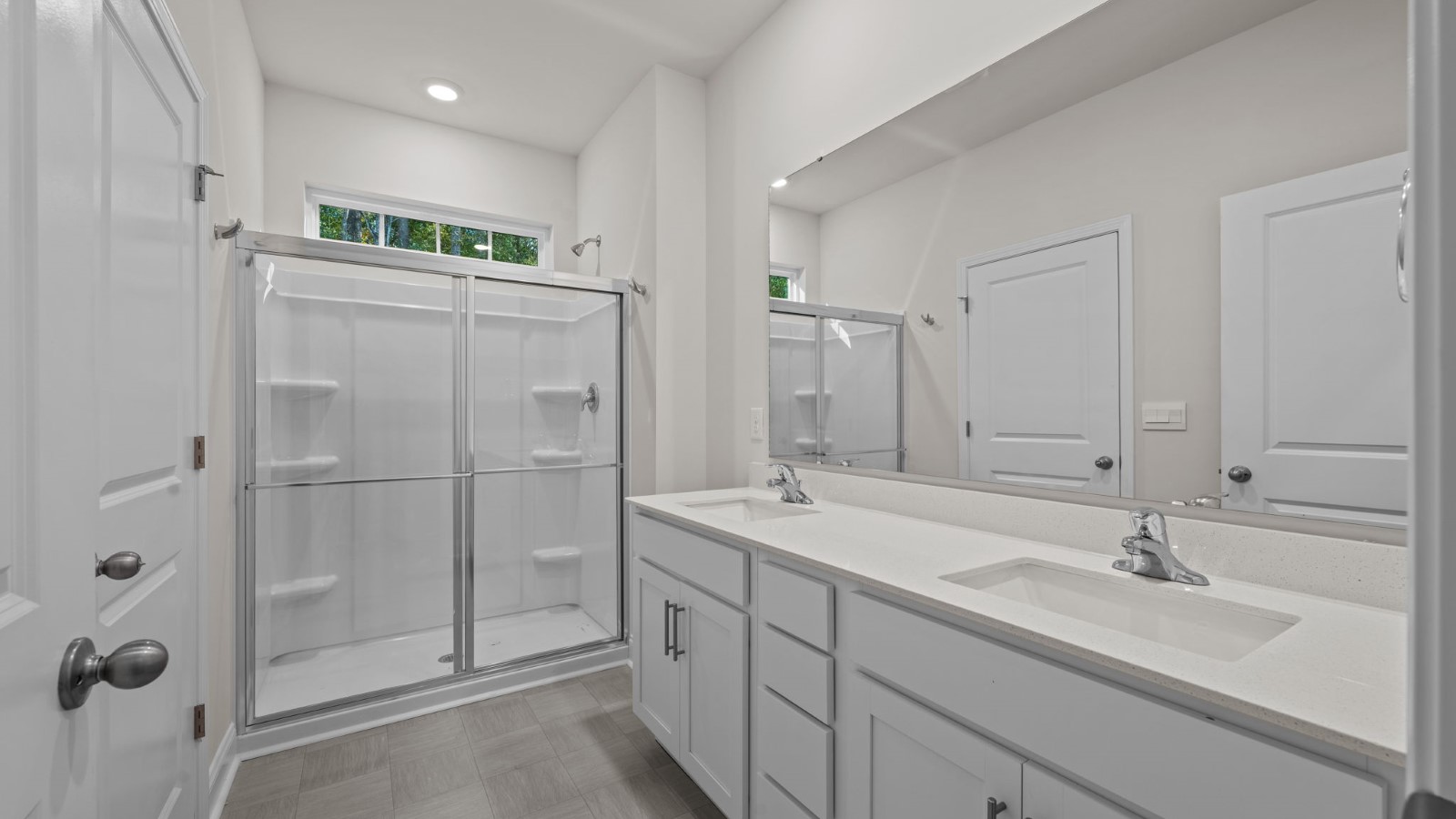 primary bathroom with double sinks and white cabinets