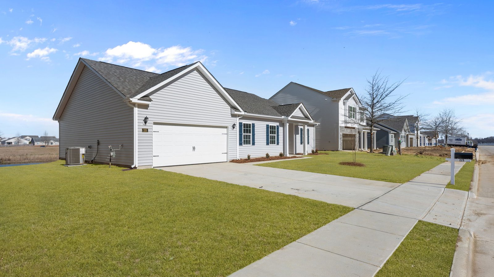 exterior view of one story home with paved driveway and yard