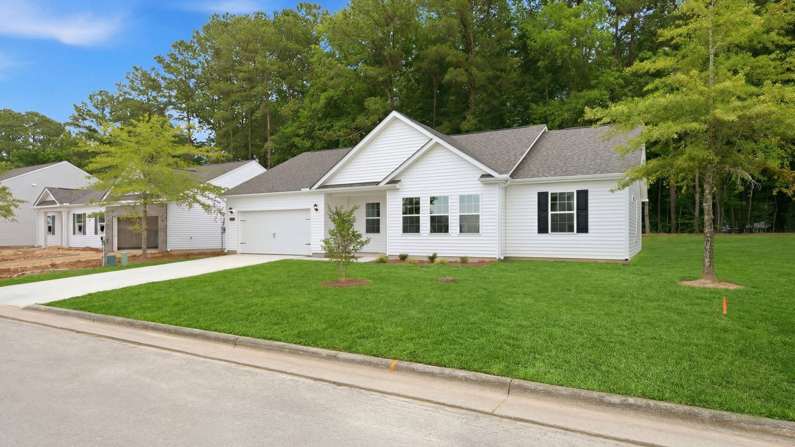 front of one story white home with driveway and garage