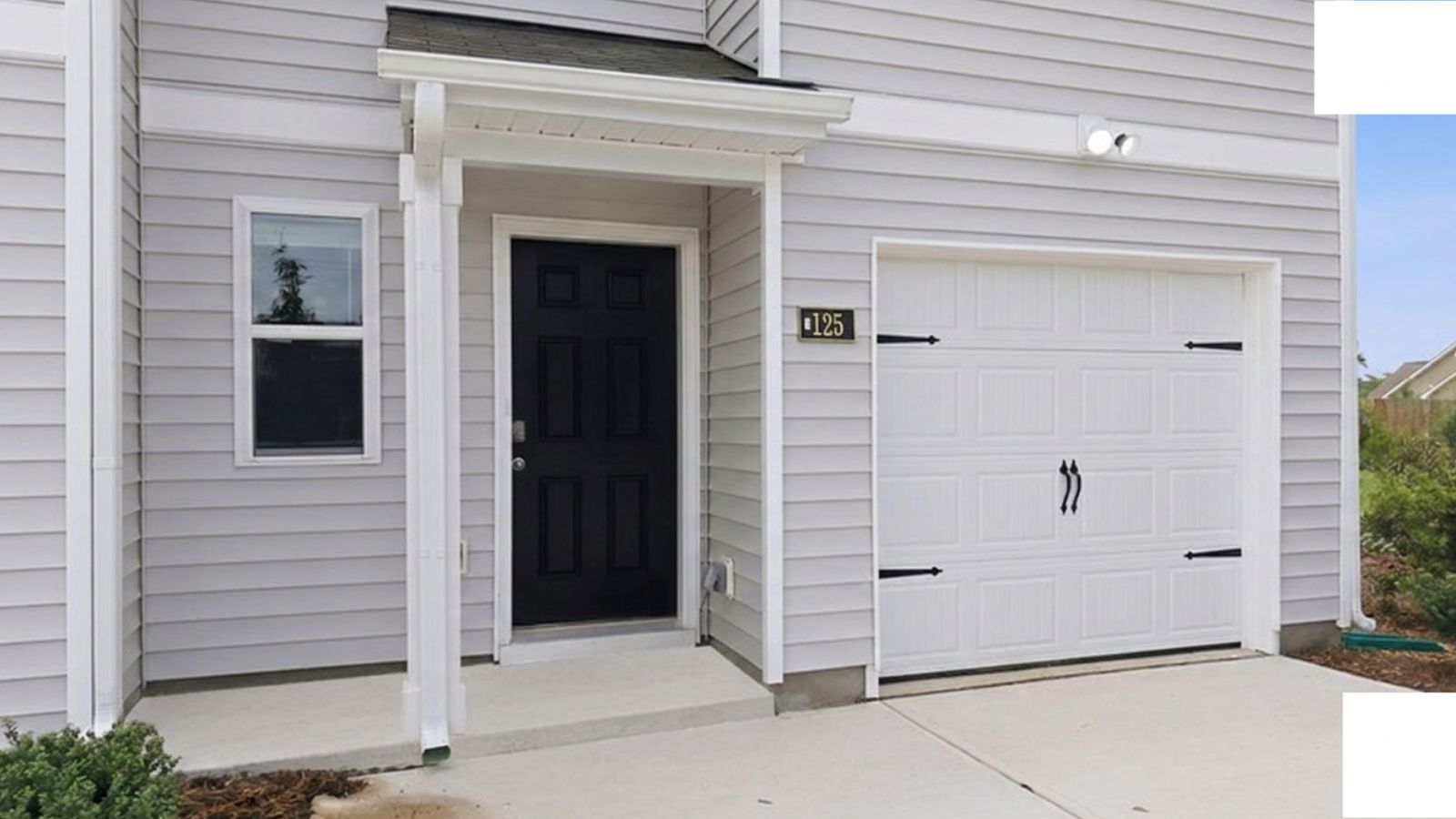 front porch of two story townhome with garage view