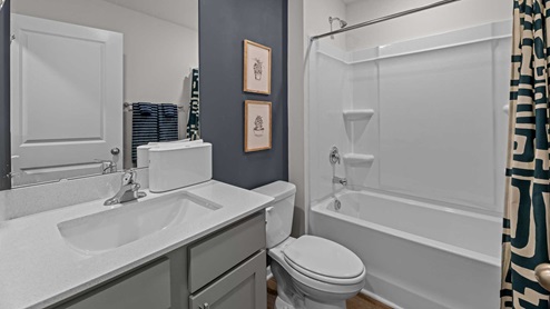 Bathroom with quartz countertops and bathtub