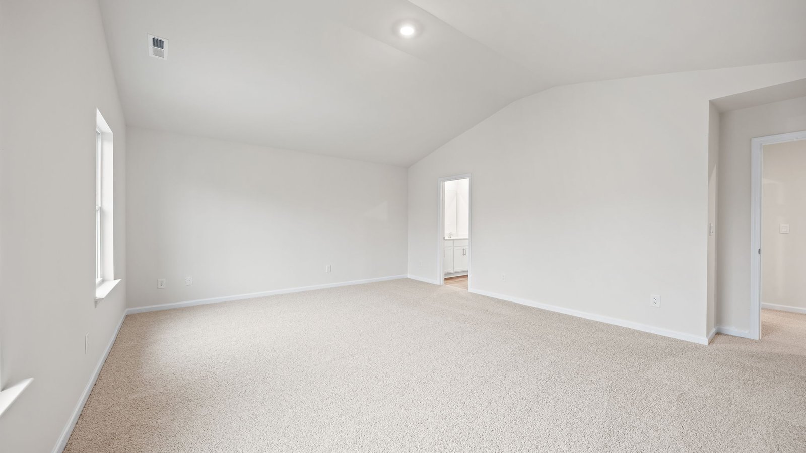 primary bedroom with vaulted ceiling