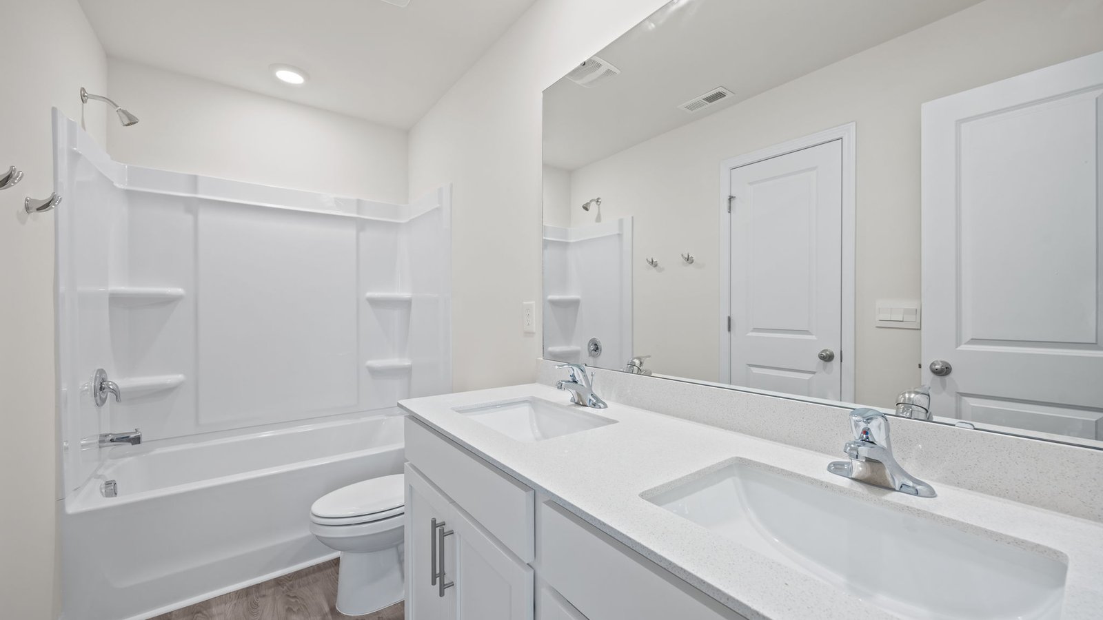 bathroom with double vanity and tub/ shower combo