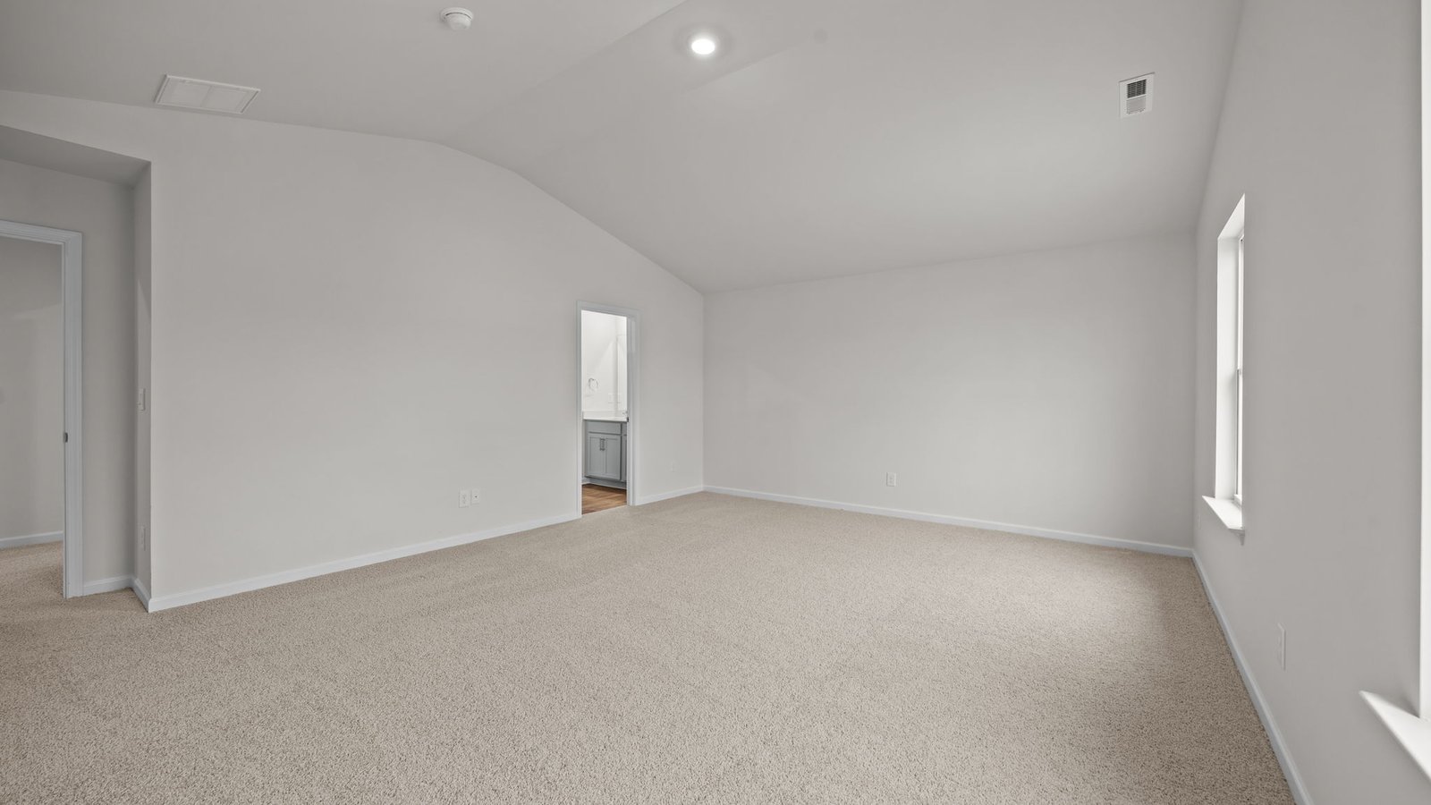 primary bedroom with faulted ceilings