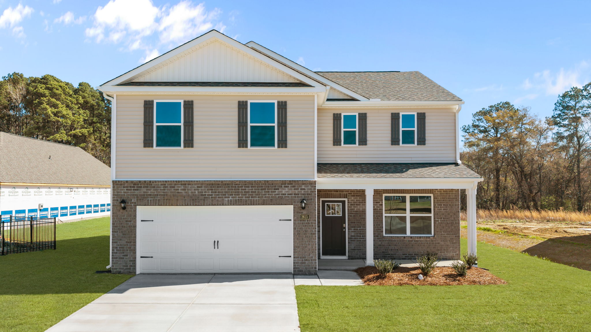 Exterior of home with brick and tan vinyl siding with shutters