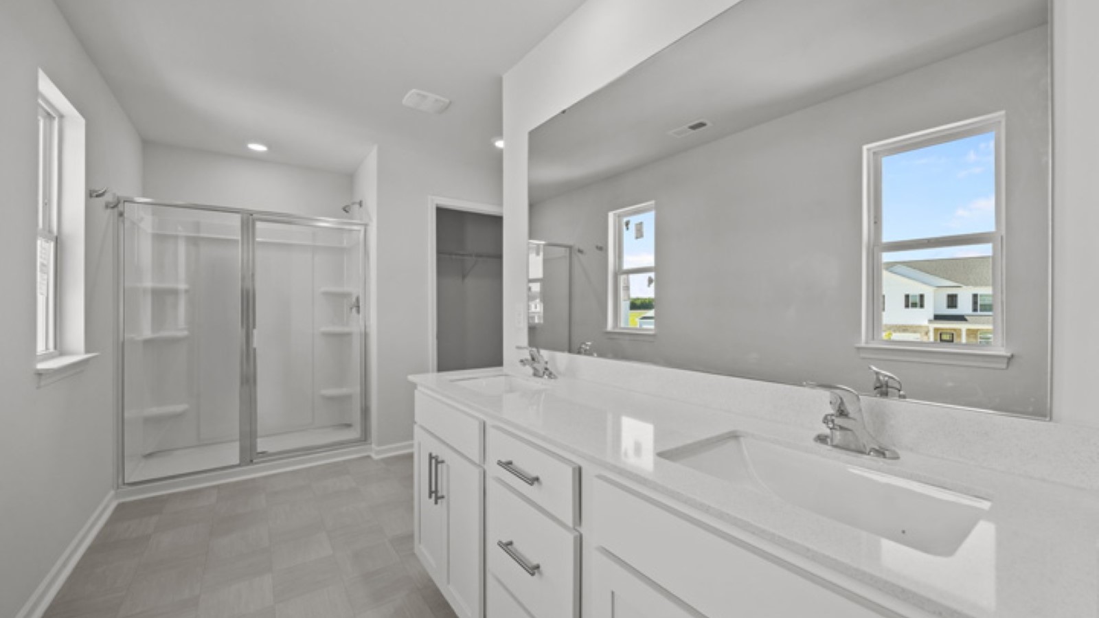 Primary bath with double sinks and white cabinets