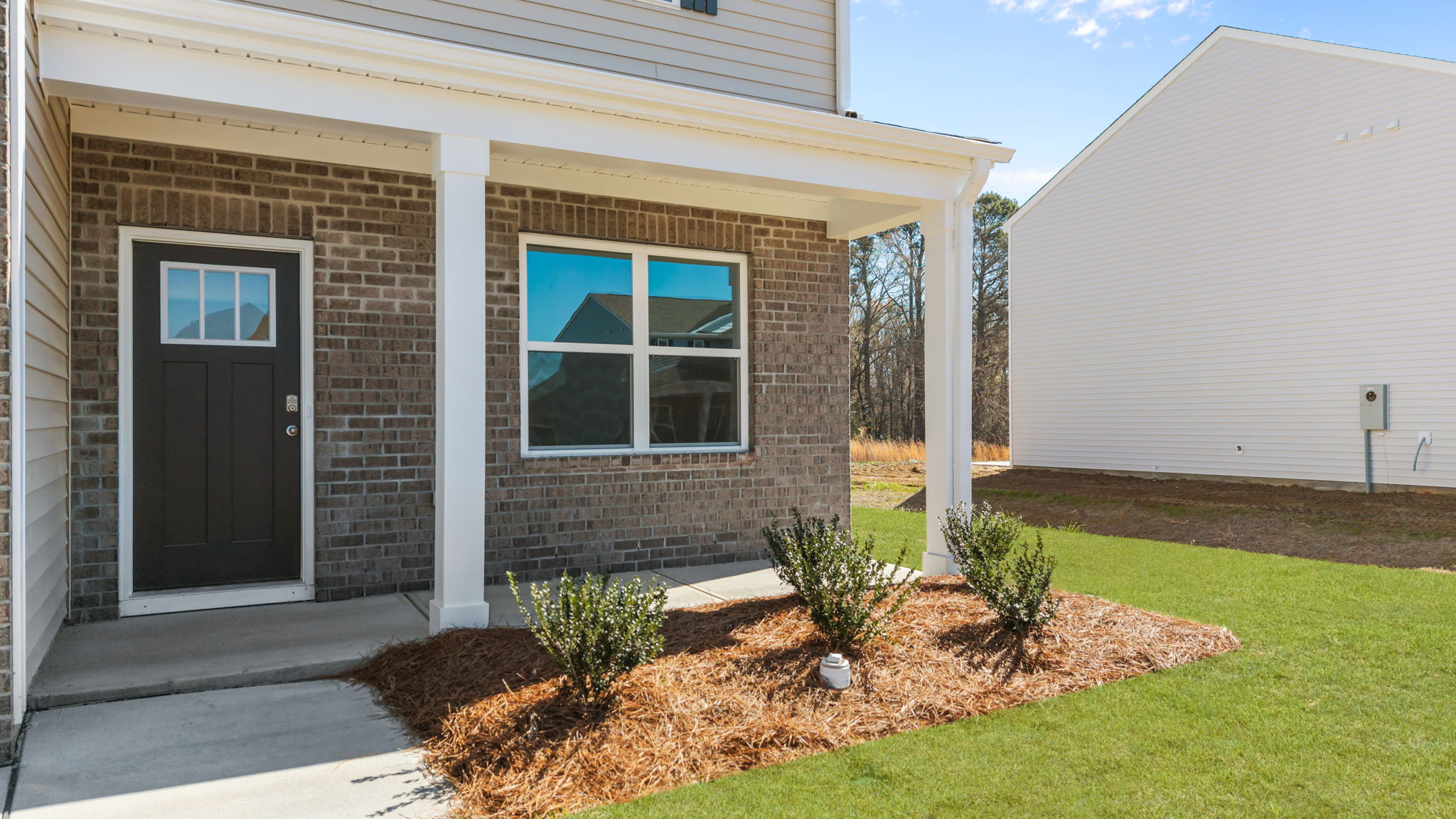 Beautiful covered front porch with landscaping