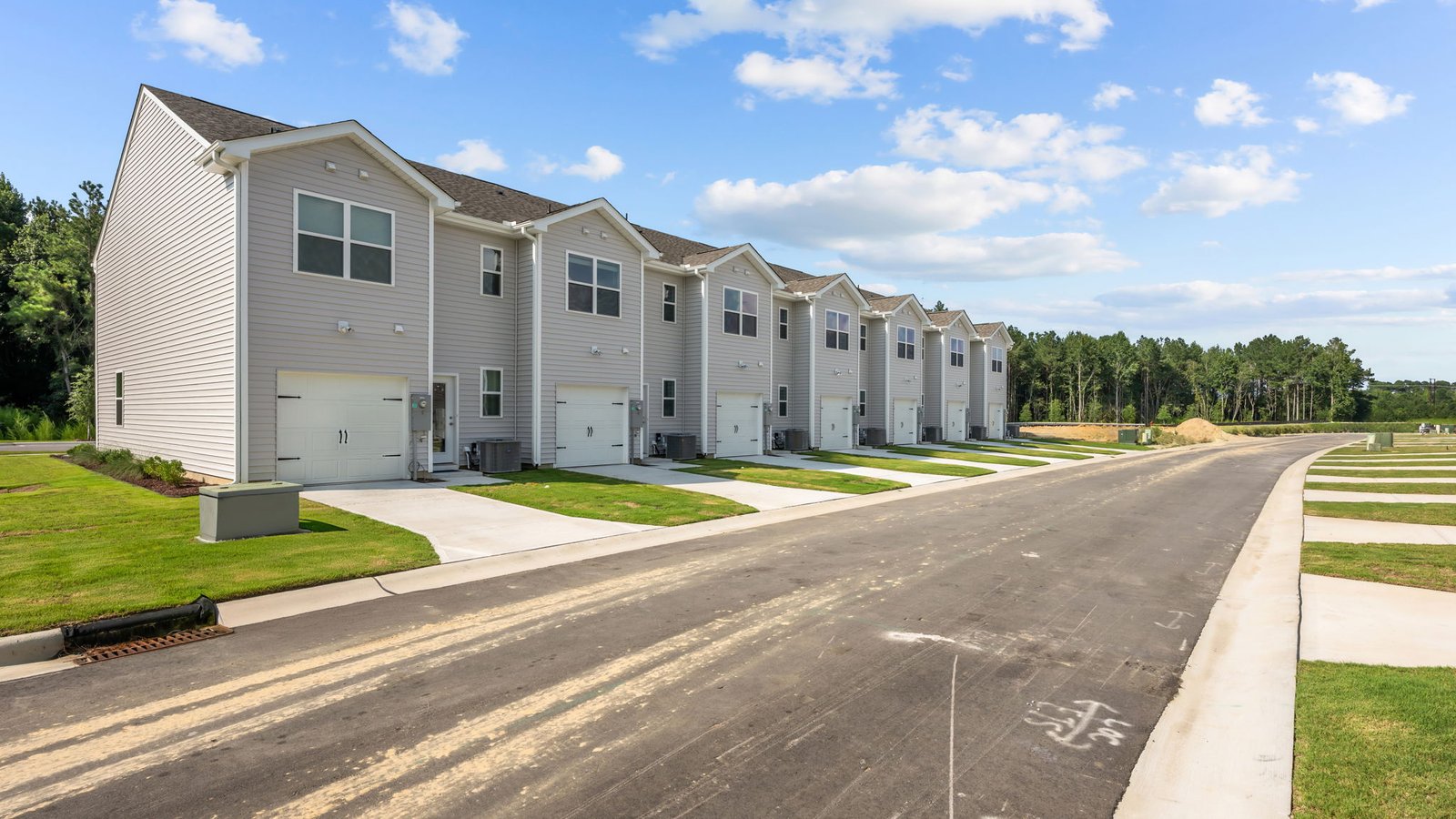 Rear view of two story townhomes with one car garage