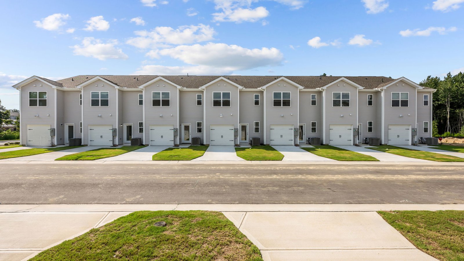 Rear view of two story townhomes with one car garage
