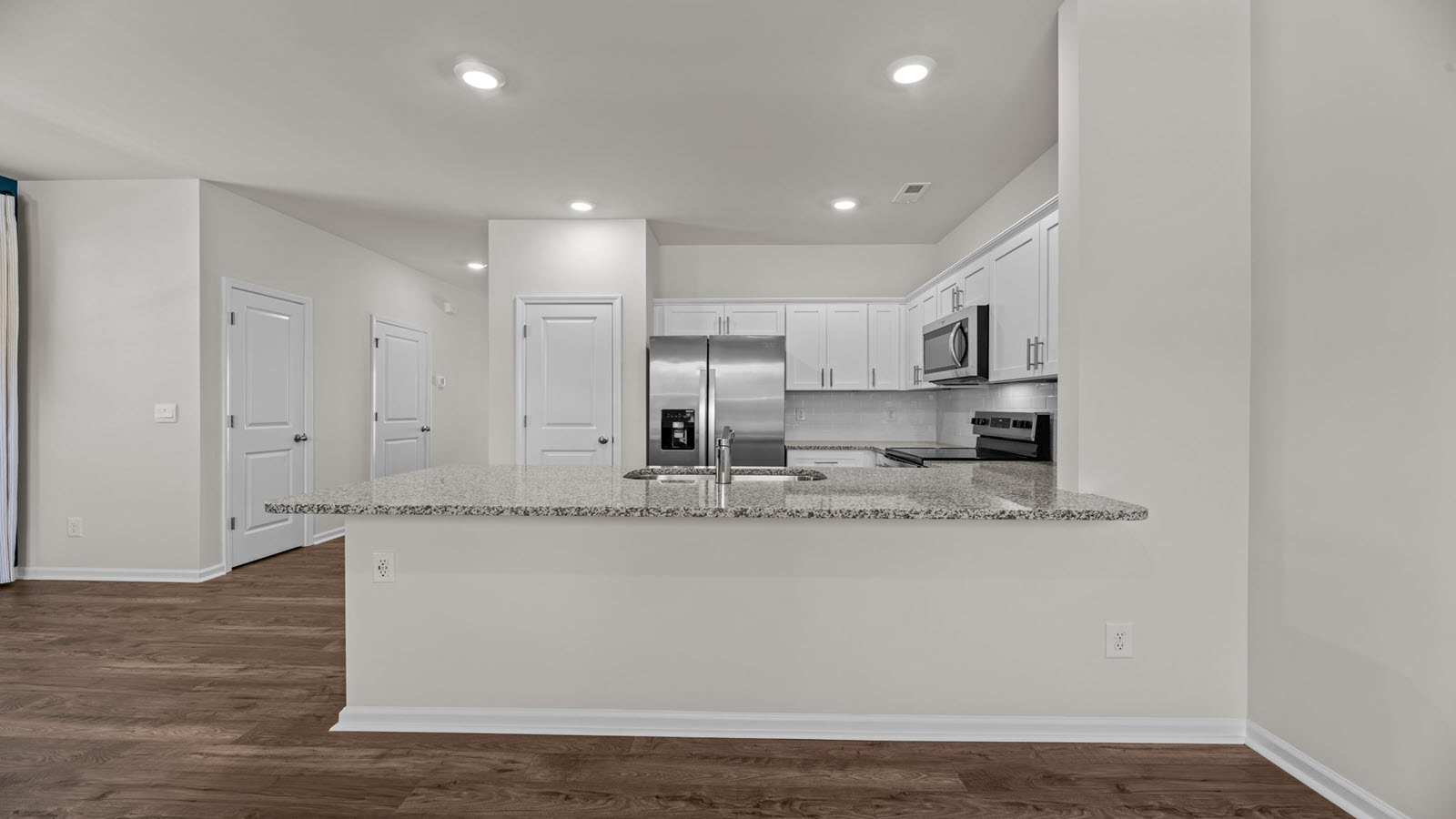 .kitchen with white cabinetry, large island and stainless steel appliances