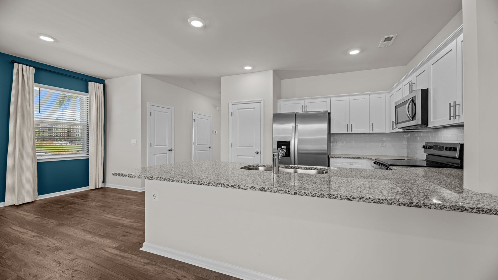 kitchen with white cabinetry, large island and stainless steel appliances