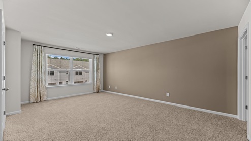 bedroom with light beige carpet and walls with a large window
