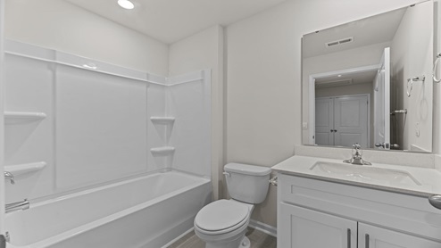 bathroom with a vanity sink, toilet and shower