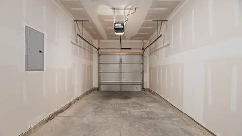 view of the one-car garage featuring concrete flooring and white walls