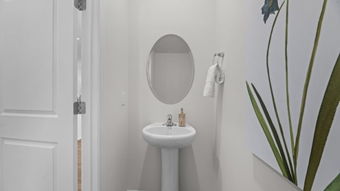 half bathroom featuring white pedestal sink and oval mirror