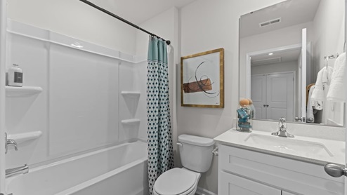 secondary bathroom featuring a single sink, quartz counters, and shower-tub combo
