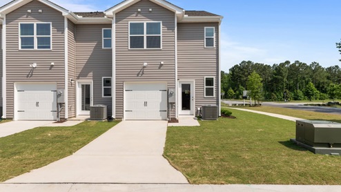 back exterior of townhome featuring garage door and driveway