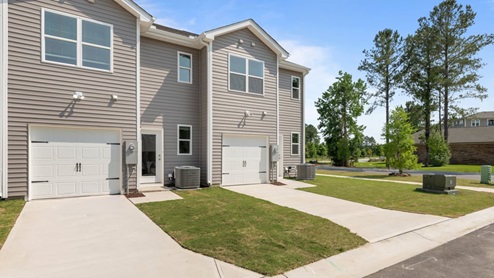 back exterior of townhome featuring garage door and driveway