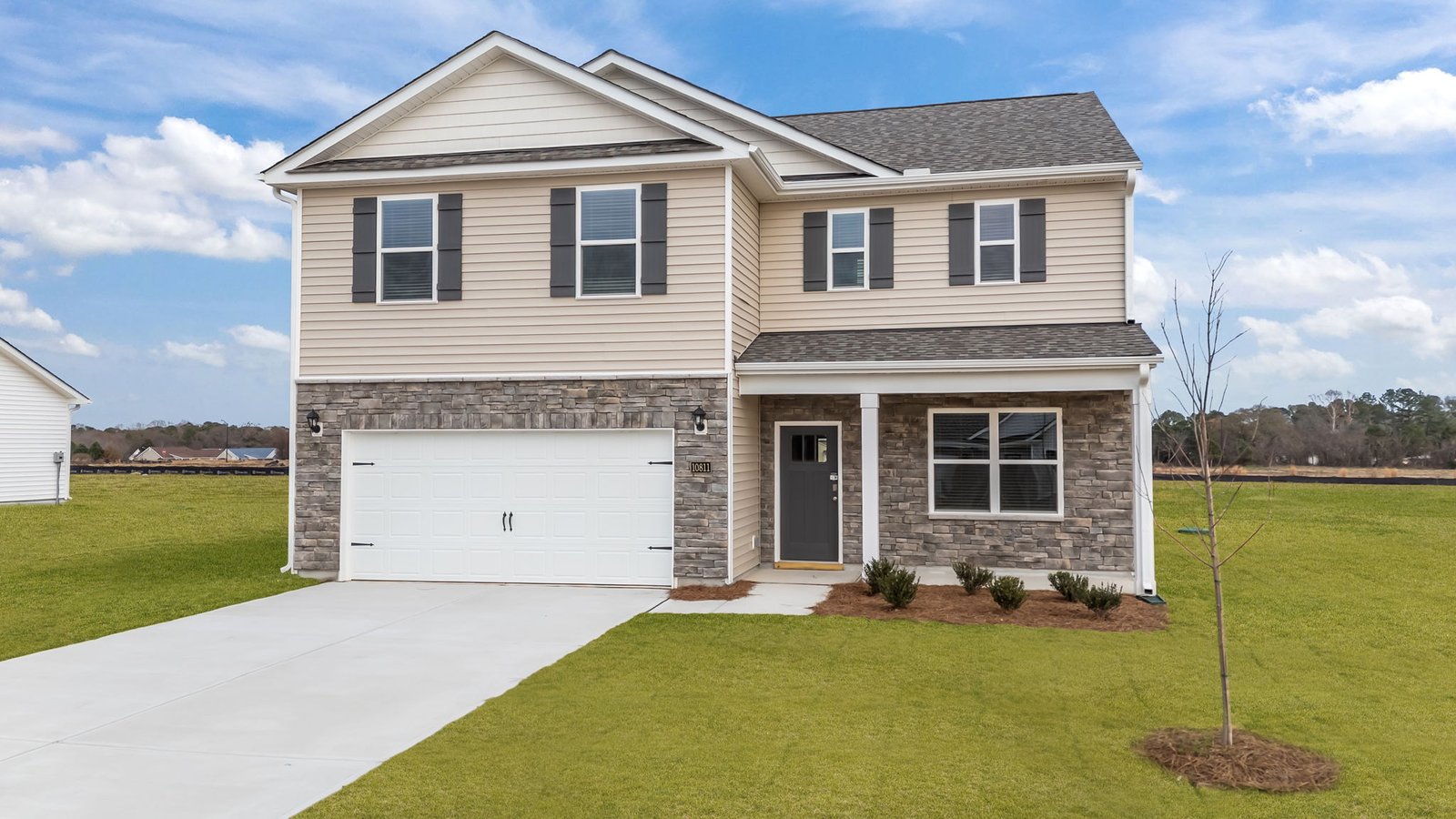 Two story home with siding and brick with covered porch and two car garage