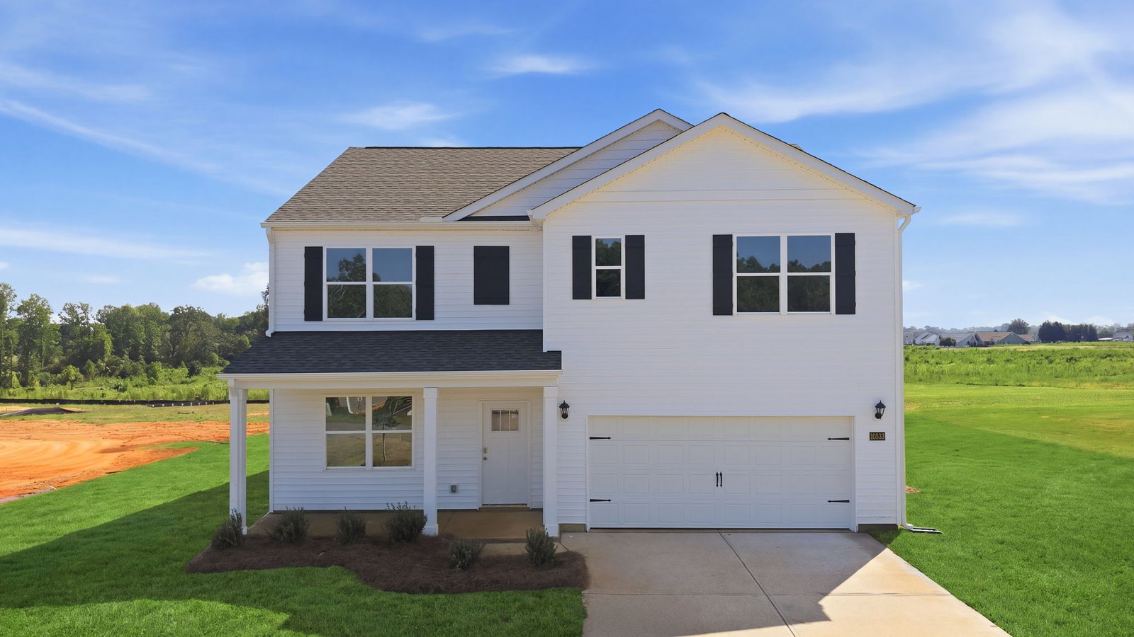 front exterior view of two story home with white vinyl and two car garage