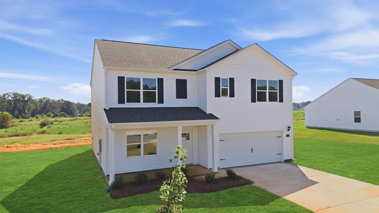 front exterior view of two story home with white vinyl and two car garage