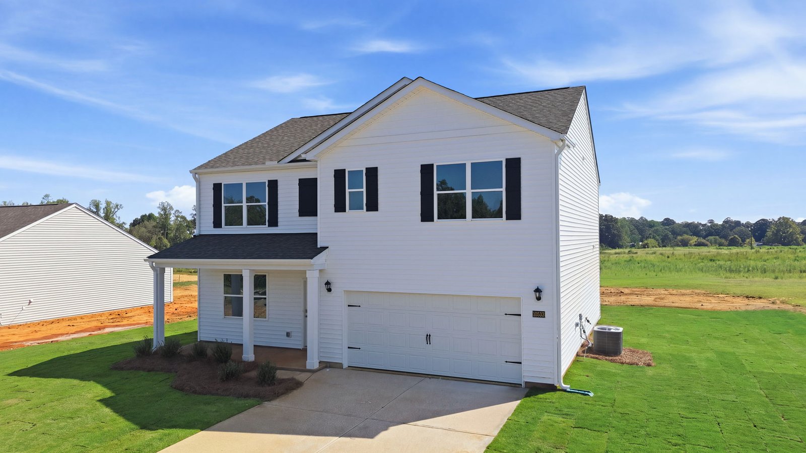 front exterior view of two story home with white vinyl and two car garage