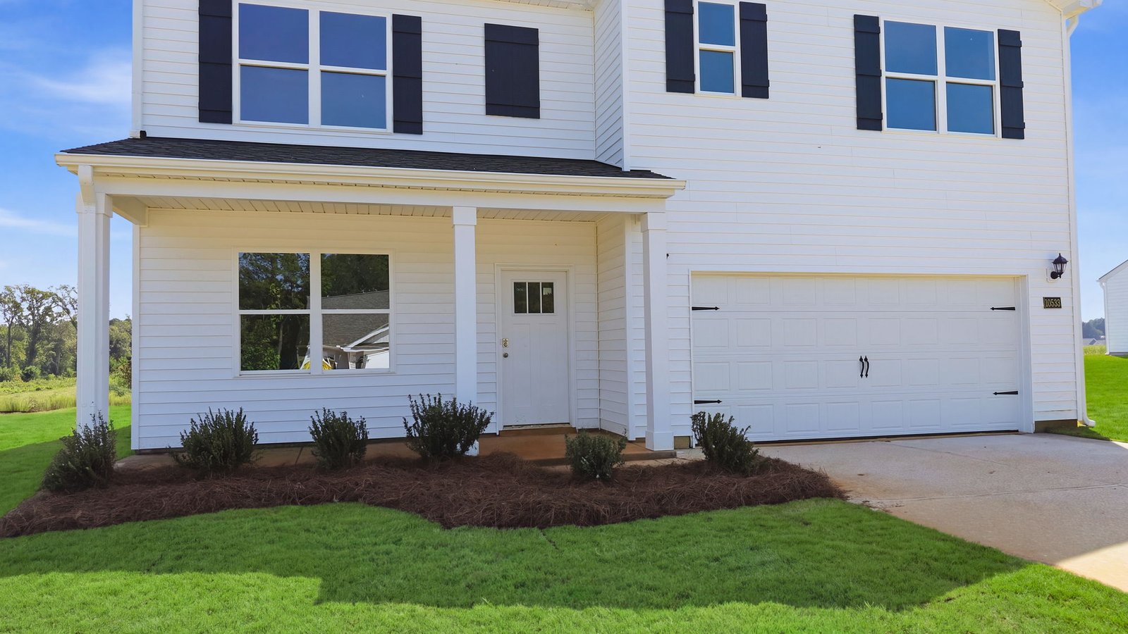 covered front porch view of two story white vinyl home