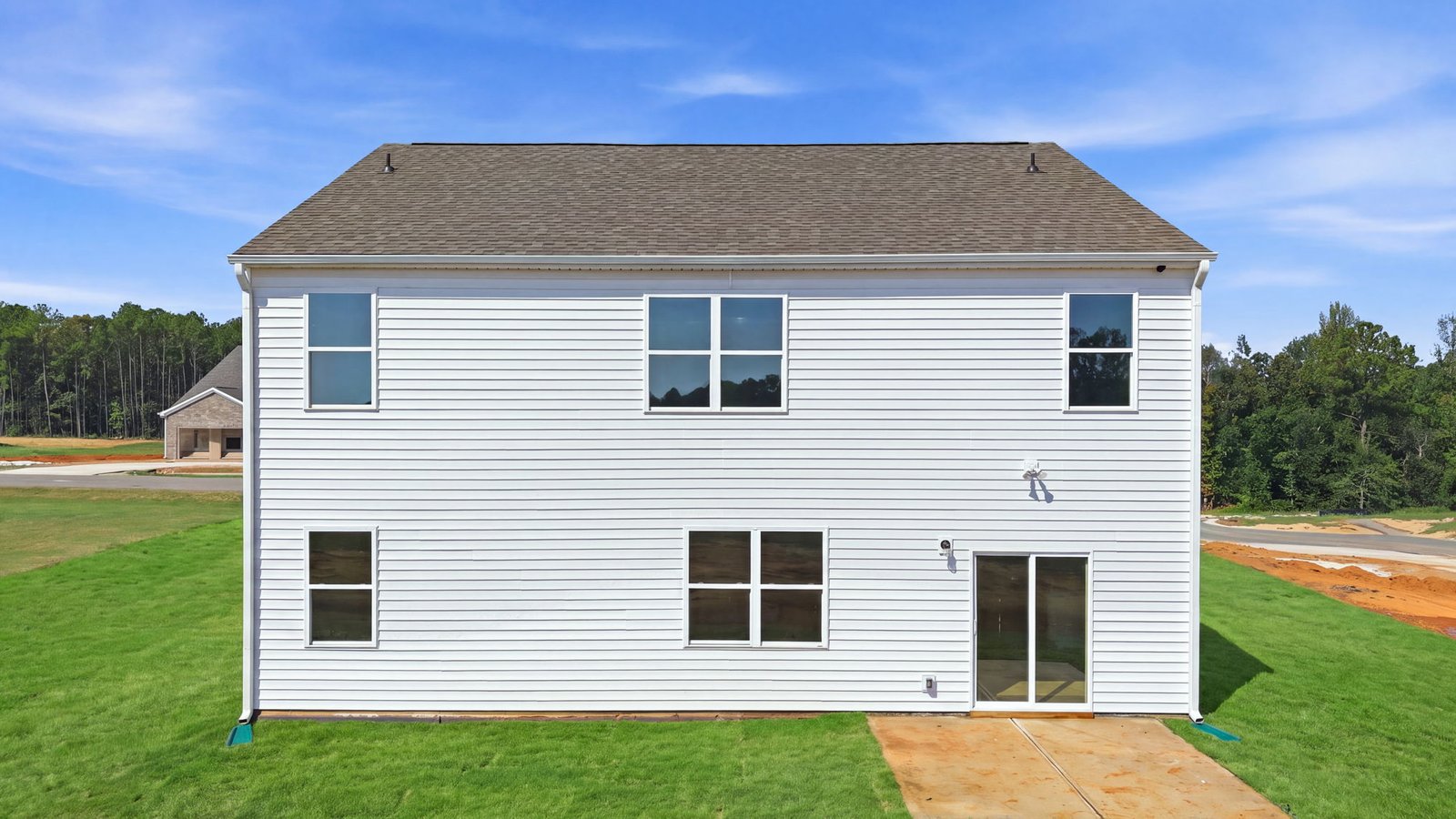 rear view of two story home with back yard and back patio pad
